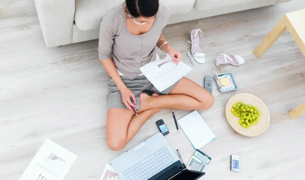 Business woman sitting in house with laptop,beside sofa