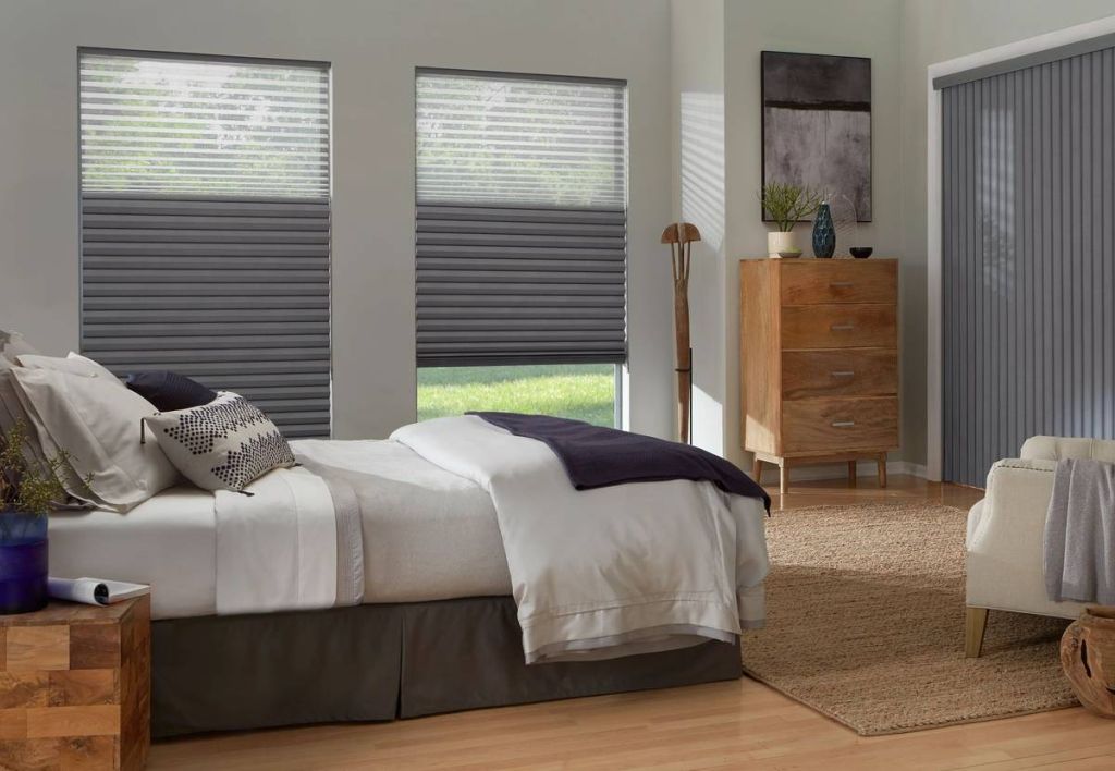 Bedroom with honeycomb room darkening shades and matching vertical application for blackout sleep.